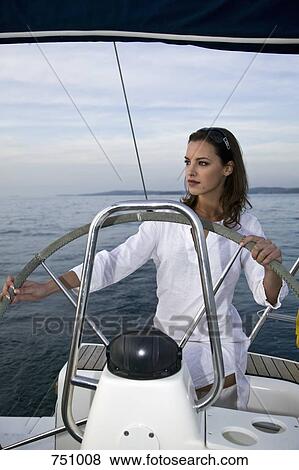 A woman at the helm of a yacht View Large Photo Image Stock Photo - A woman at the helm of a yacht. Fotosearch