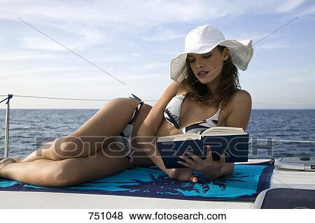 Stock Photo - A woman reading on a yacht. Fotosearch