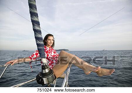 A woman sitting on the bow of a yacht View Large Photo Image Picture - A woman sitting on the bow of a yacht. Fotosearch