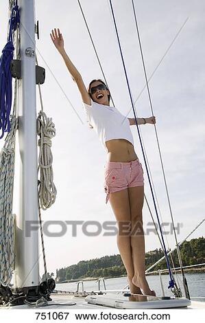 A woman standing on a yacht and waving View Large Photo Image Stock Photo - A woman standing on a yacht and waving. Fotosearch