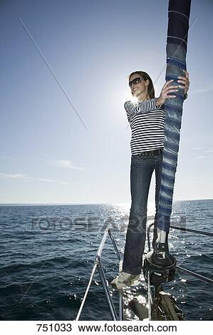 A woman standing on the bow of a yacht View Large Photo Image Stock Image - A woman standing on the bow of a yacht. Fotosearch