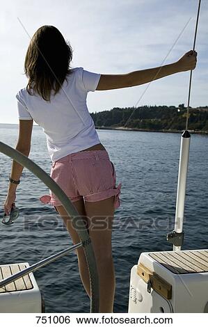 Stock Photograph - Rear view of a woman standing on a yacht. Fotosearch