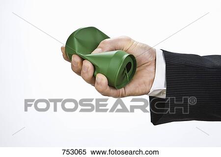 Stock Photography - A hand crushing a silver can. Fotosearch