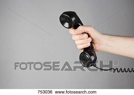 A hand holding a telephone receiver View Large Photo Image Stock Photograph - A hand holding a telephone receiver. Fotosearch