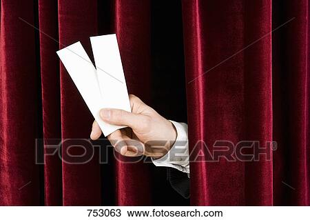 A hand holding two tickets through a red velvet curtain View Large Photo Image Stock Image - A hand holding two tickets through a red velvet curtain. Fotosearch