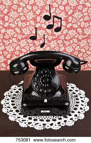 Stock Image - An old fashioned telephone on a dresser with musical notes. Fotosearch