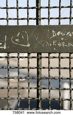 Graffiti scratched into a metal fence View Large Photo Image Stock Image - Graffiti scratched into a metal fence . Fotosearch