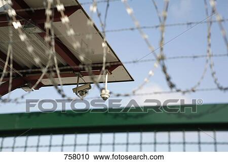 Security cameras and a barbed wire fence View Large Photo Image Stock Image - Security cameras and a barbed wire fence. Fotosearch