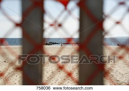 Stock Photograph - View of a beach through railings. Fotosearch