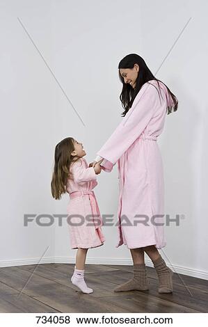 A daughter and mother in pink bathrobes holding hands View Large Photo Image Stock Photo - A daughter and mother in pink bathrobes holding hands. Fotosearch