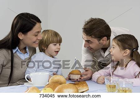 Stock Photography - A family celebrating a the birthday of their son. Fotosearch