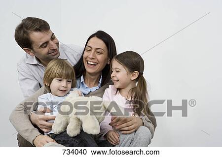 Stock Image - A family of four laughing together. Fotosearch