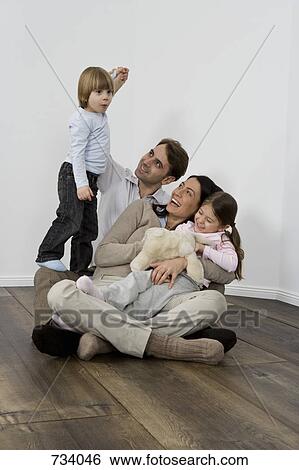 Stock Photograph - A family of four laughing together. Fotosearch