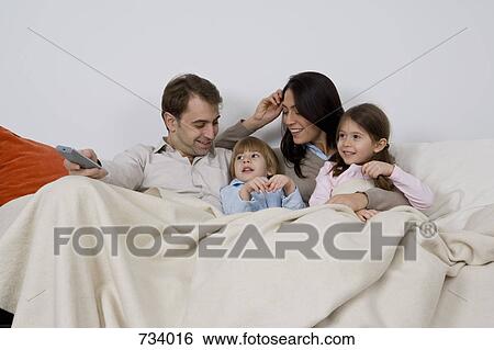 A family of four watching TV View Large Photo Image Stock Photograph - A family of four watching TV. Fotosearch