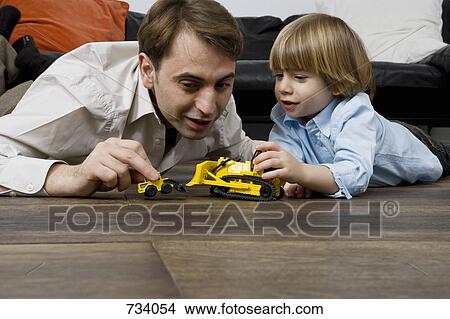 A father and son playing with toy trucks View Large Photo Image Picture - A father and son playing with toy trucks. Fotosearch