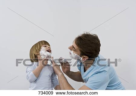 A father applying shaving cream to his young son View Large Photo Image Stock Photo - A father applying shaving cream to his young son. Fotosearch