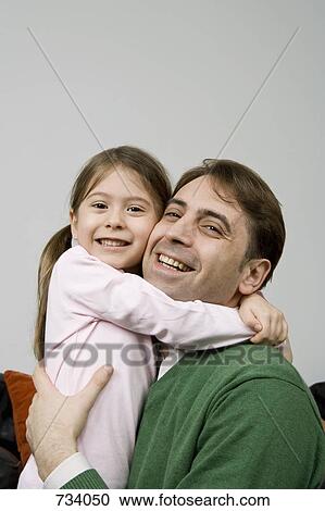 Stock Image - A father embracing his daughter. Fotosearch