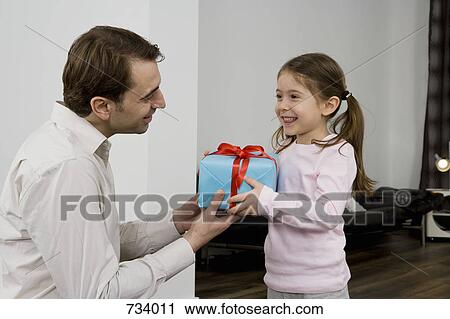 A father giving his daughter a present View Large Photo Image Stock Image - A father giving his daughter a present. Fotosearch
