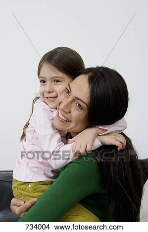 Picture - A mother and her small daughter embracing. Fotosearch