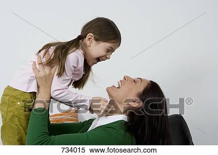 A mother holding her daughter up View Large Photo Image Stock Photography - A mother holding her daughter up. Fotosearch
