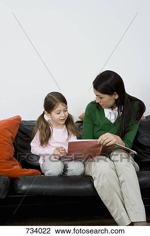 A mother reading a book to her daughter View Large Photo Image Stock Image - A mother reading a book to her daughter. Fotosearch