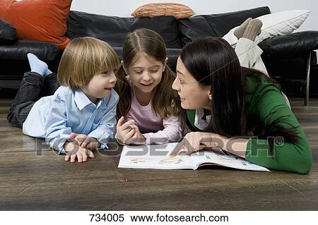 Stock Photography - A mother reading a book to her two children. Fotosearch