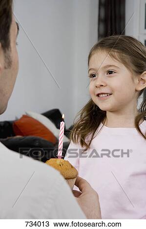 A young girl receiving a muffin with a birthday candle View Large Photo Image Stock Image - A young girl receiving a muffin with a birthday candle. Fotosearch