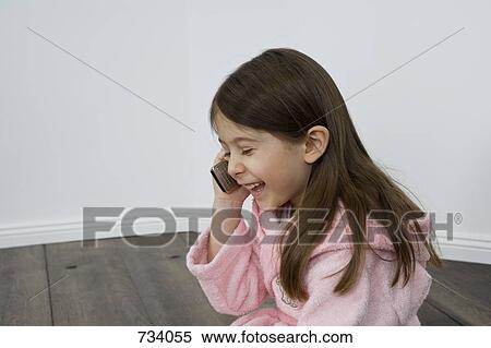 A young girl talking on a cell phone View Large Photo Image Stock Photography - A young girl talking on a cell phone. Fotosearch