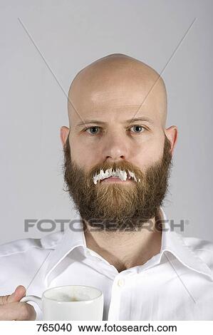Stock Image - A man with a milk moustache on his real mustache. Fotosearch