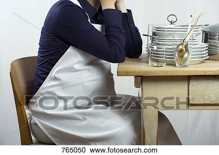 A pregnant woman sitting a table stacked with dishes View Large Photo Image Stock Image - A pregnant woman sitting a table stacked with dishes. Fotosearch