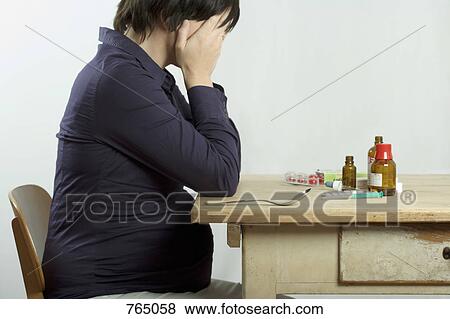 A pregnant woman sitting at a table filled with drugs View Large Photo Image Stock Photo - A pregnant woman sitting at a table filled with drugs. Fotosearch