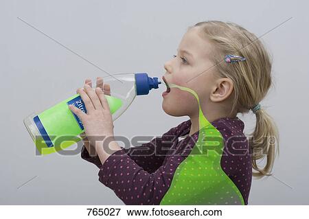 Stock Photo - A young girl drinking from a bottle of cleaning fluid. Fotosearch