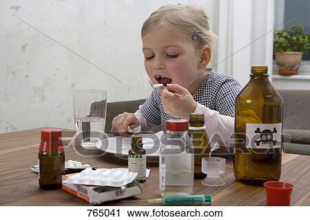 A young girl eating a pill surrounded by medicines View Large Photo Image Stock Image - A young girl eating a pill surrounded by medicines. Fotosearch