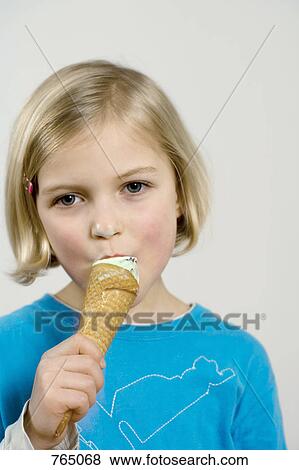 A young girl eating an ice cream cone View Large Photo Image Stock Photo - A young girl eating an ice cream cone. Fotosearch