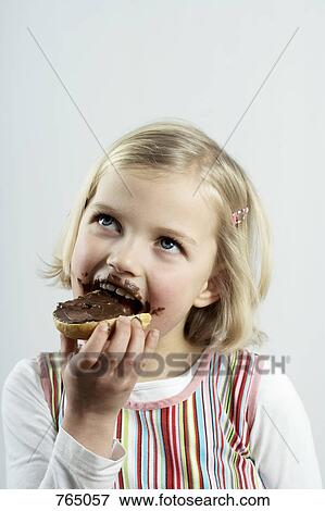 A young girl eating bread and chocolate spread View Large Photo Image Stock Photo - A young girl eating bread and chocolate spread. Fotosearch