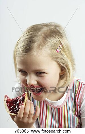 A young girl giggling while eating a bread and jam View Large Photo Image Stock Photography - A young girl giggling while eating a bread and jam. Fotosearch