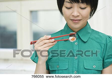 A woman eating sushi View Large Photo Image Stock Photography - A woman eating sushi. Fotosearch
