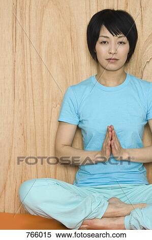 Stock Photography - A woman sitting in the lotus position. Fotosearch