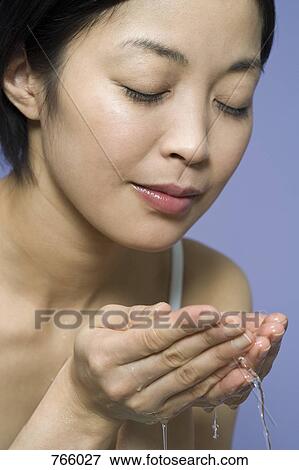 A woman washing her face View Large Photo Image Stock Photo - A woman washing her face. Fotosearch