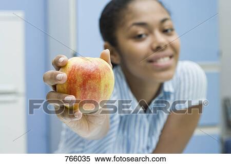 Stock Photography - A young woman holding an apple. Fotosearch