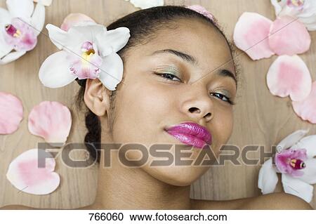 A young woman lying surrounded by flowers View Large Photo Image Stock Image - A young woman lying surrounded by flowers. Fotosearch