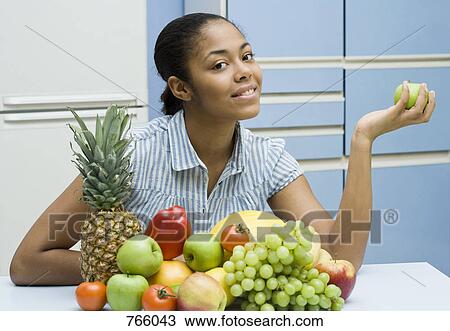 A young woman sitting with fruit View Large Photo Image Stock Image - A young woman sitting with fruit. Fotosearch