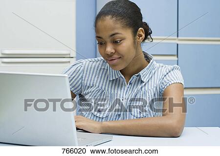 A young woman using her laptop View Large Photo Image Stock Image - A young woman using her laptop. Fotosearch