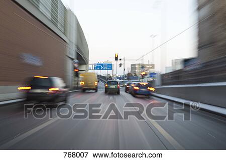 Rear view of vehicles driving along a road at speed View Large Photo Image Stock Photo - Rear view of vehicles driving along a road at speed. Fotosearch