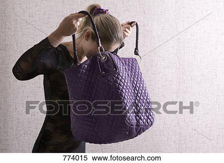 A woman looking into her large purse View Large Photo Image Stock Photography - A woman looking into her large purse. Fotosearch