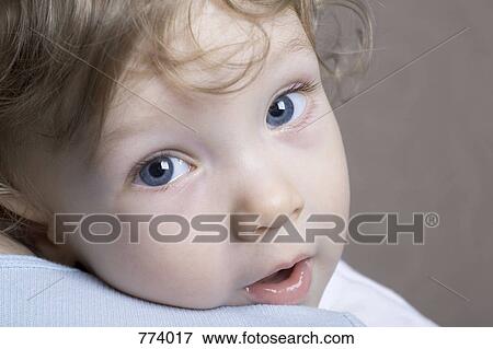 Stock Photo - A young boy being held, over the shoulder view. Fotosearch