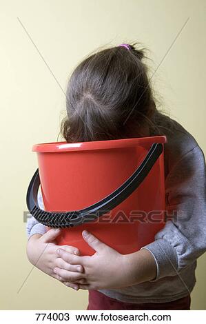A young girl being sick in a bucket View Large Photo Image Stock Image - A young girl being sick in a bucket. Fotosearch