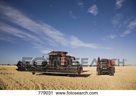 Stock Image - A combine and tractor in a field. Fotosearch