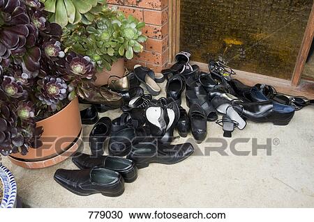 A heap of shoes outside of a door View Large Photo Image Stock Image - A heap of shoes outside of a door. Fotosearch