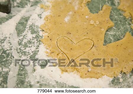 Picture - A heart shaped cookie in dough. Fotosearch